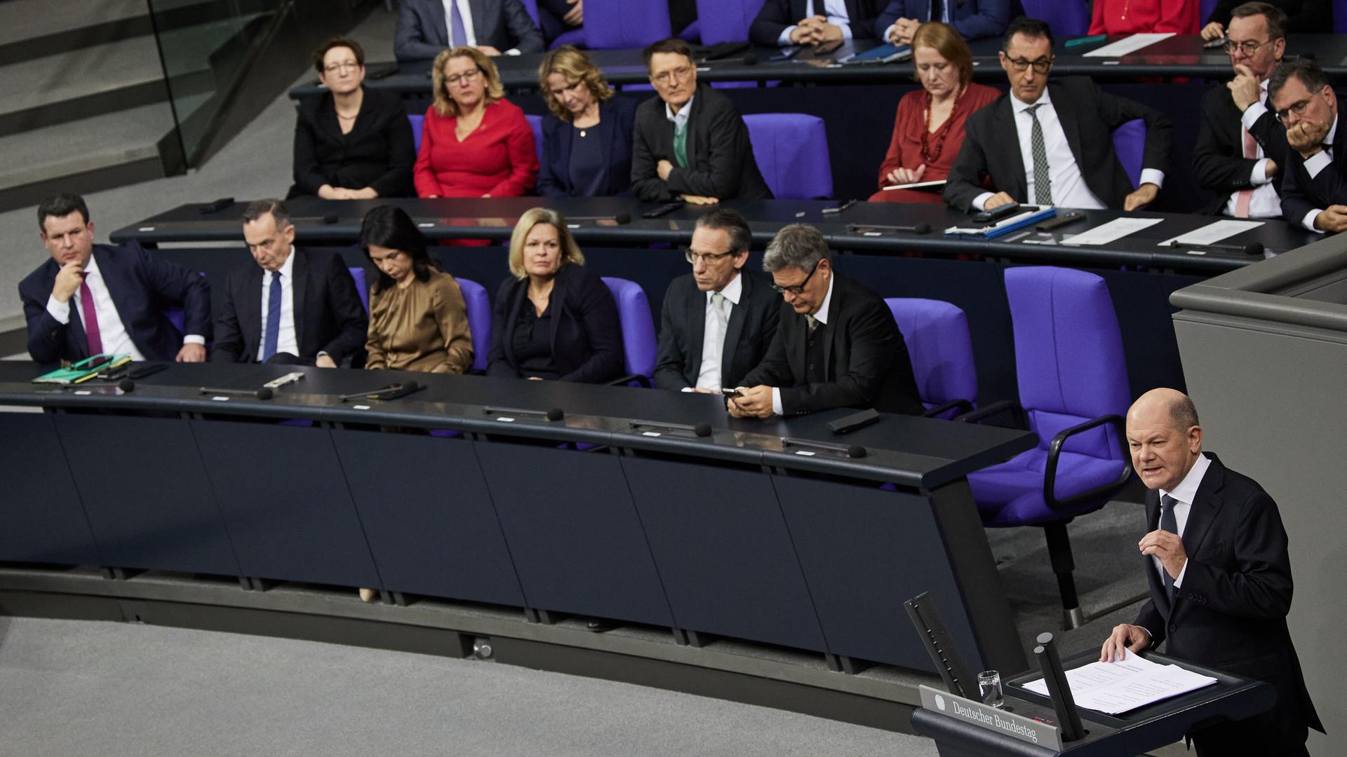 Bundeskanzler Olaf Scholz (SPD) spricht im Bundestag und stellt die Vertrauensfrage. Dahinter die Regierungsbank mit Politikerinnen und Politikern von SPD und Grünen.