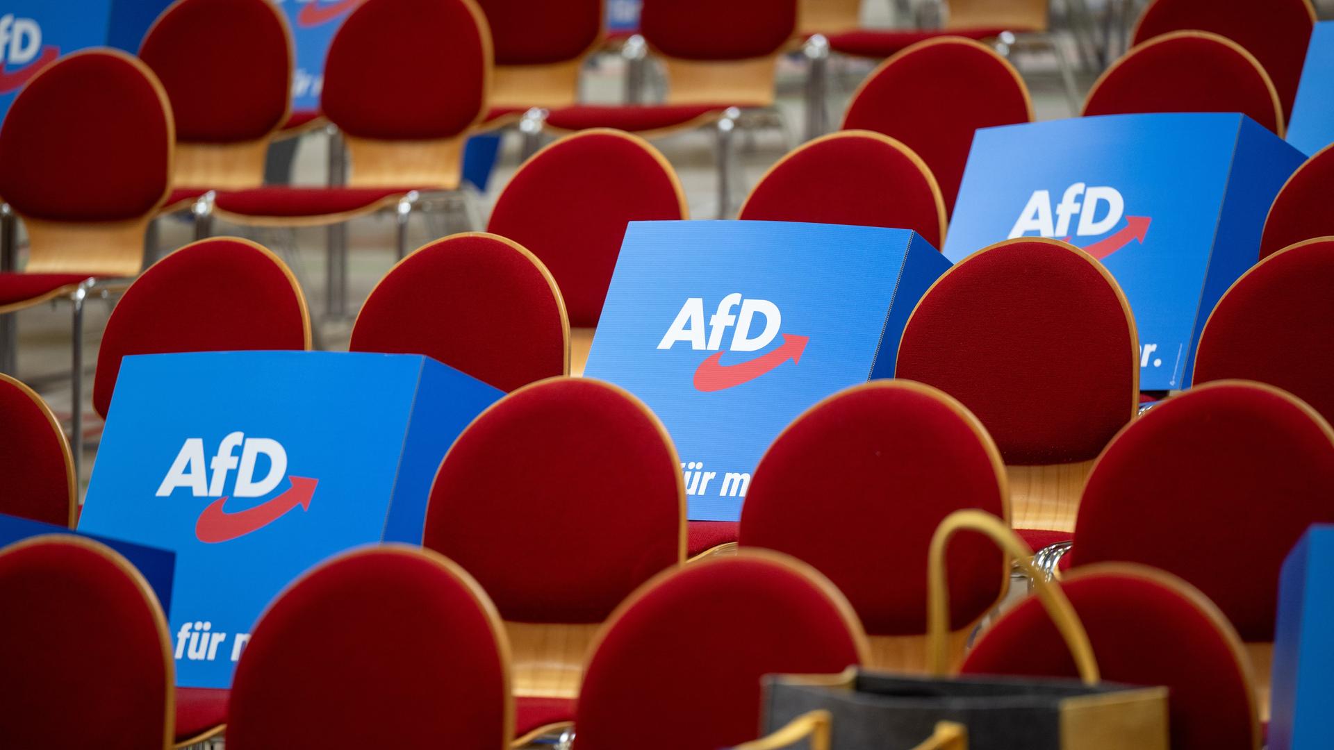 Pappaufsteller mit dem Logo der AfD liegen vor Beginn des Landesparteitags der AfD Brandenburg auf den Stühlen in der Wiesenhalle. 