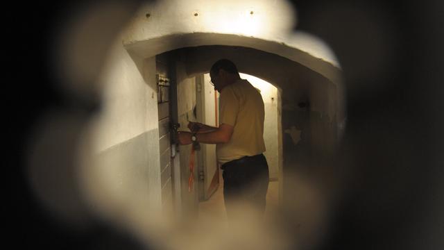 Mitarbeiter Michael Wildt von der Initiativgruppe Geschlossener Jugendwerkhof Torgau e.V. steht vor einer Zellentür im Dunkelzellentrakt des ehemaligen Jugendwerkhofes in Torgau. 