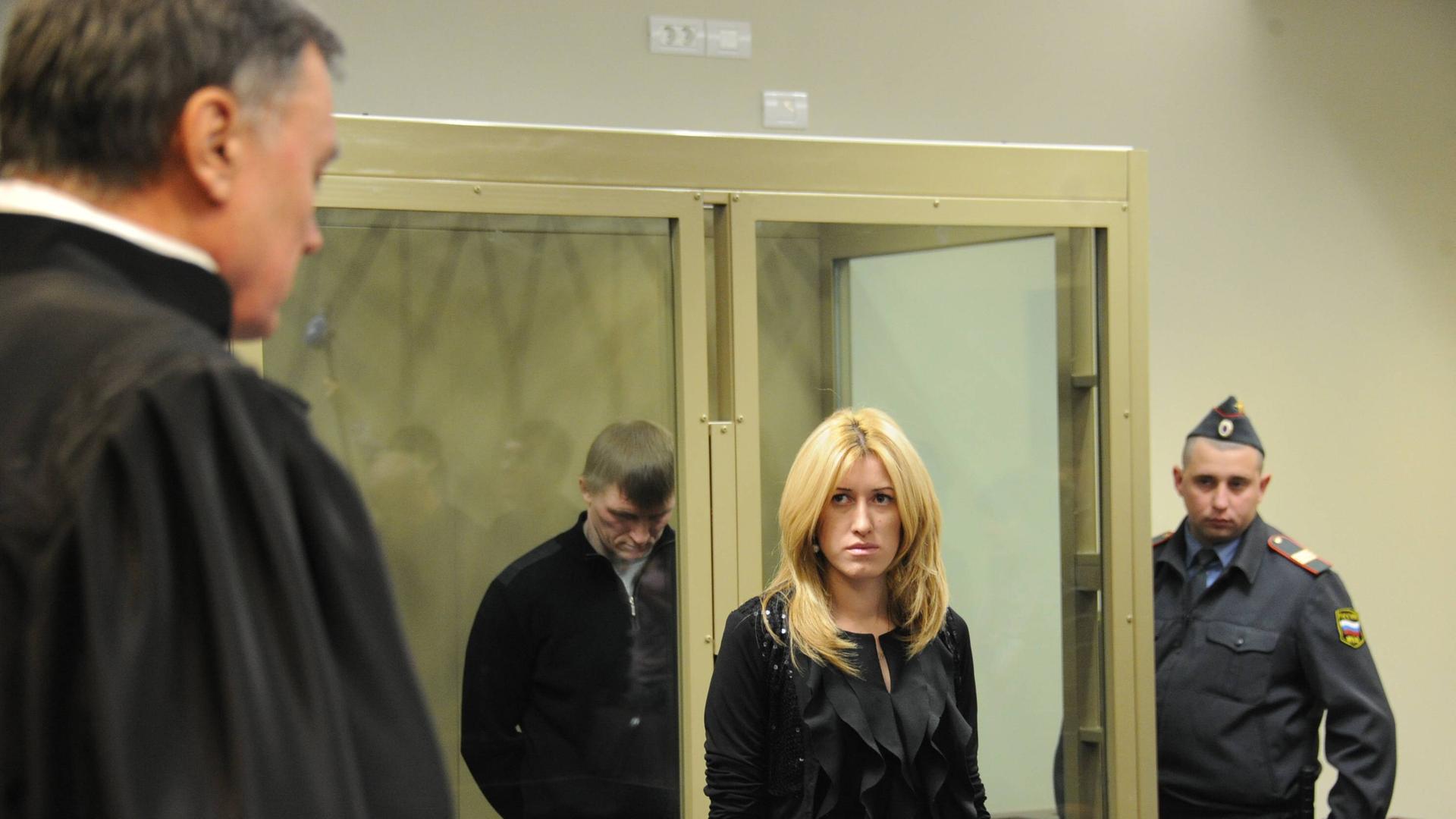 Im Gericht des Territoriums Krasnodar verliest am 27. Dezember 2011 der Richter, der ganz links im Bild steht, das Urteil gegen ein Mitglied der Zapok-Bande vor. Der Angeklagte steht mit gebeugtem Kopf in einer verglasten Box, davor steht eine blonde Frau in schwarzer Kleidung, rechts von ihr ein Mann in Uniform.