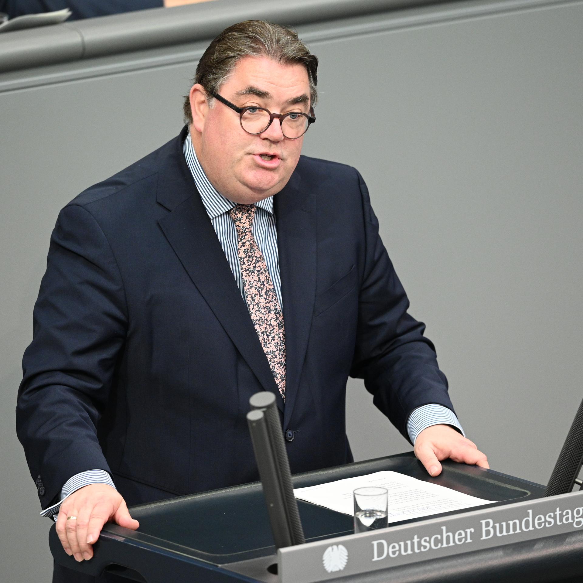 Der CDU-Abgeordnete Ansgar Heveling spricht in einer Debatte im Bundestag. Er trägt einen dunkelblauen Anzug, ein gestreiftes Hemd und eine bunte Krawatte. 