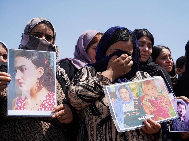 Trauerzeremonie im Lager Chamishko (Region Kurdistan im Irak) anlässlich des 10. Jahrestags des Völkermords an den Jesiden im August 2024.  Weinende Frauen halten Fotos von vermissten Angehörigen in den Händen.  