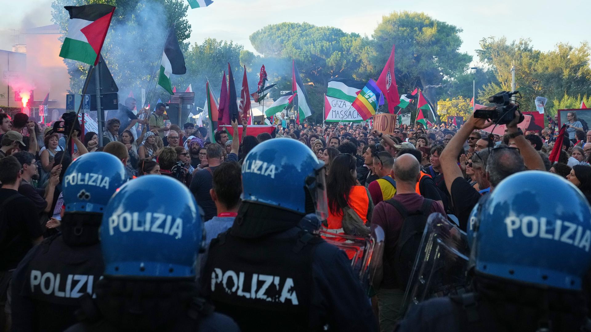 Auf dem Foto sind zahlreiche Demonstranten mit Fahnen und Transparenten zu sehen. Im Vordergrund stehen Polizisten. Auf dem Foto sind zahlreiche Demonstranten mit Fahnen und Transparenten zu sehen. Im Vordergrund stehen Polizisten.