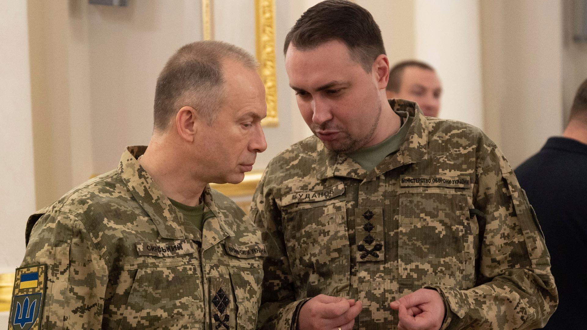 Der neue ukrainische Armeechef Syrsky spricht mit General Budanov. Beide sind in militärischer Tarnkleidung.