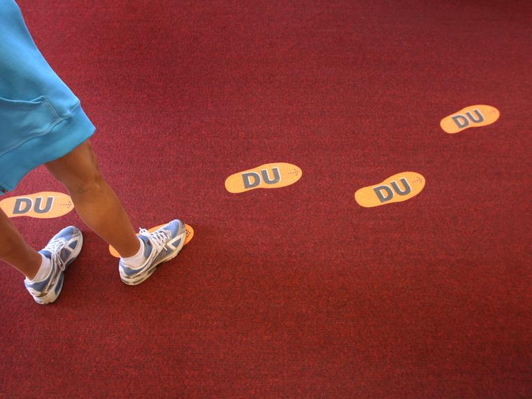 Aufgeklebte Fußstapfen mit der Aufschrift "DU" führen im Haus des Gastes in Oberstaufen (Schwaben) zum "Du"-Schalter.