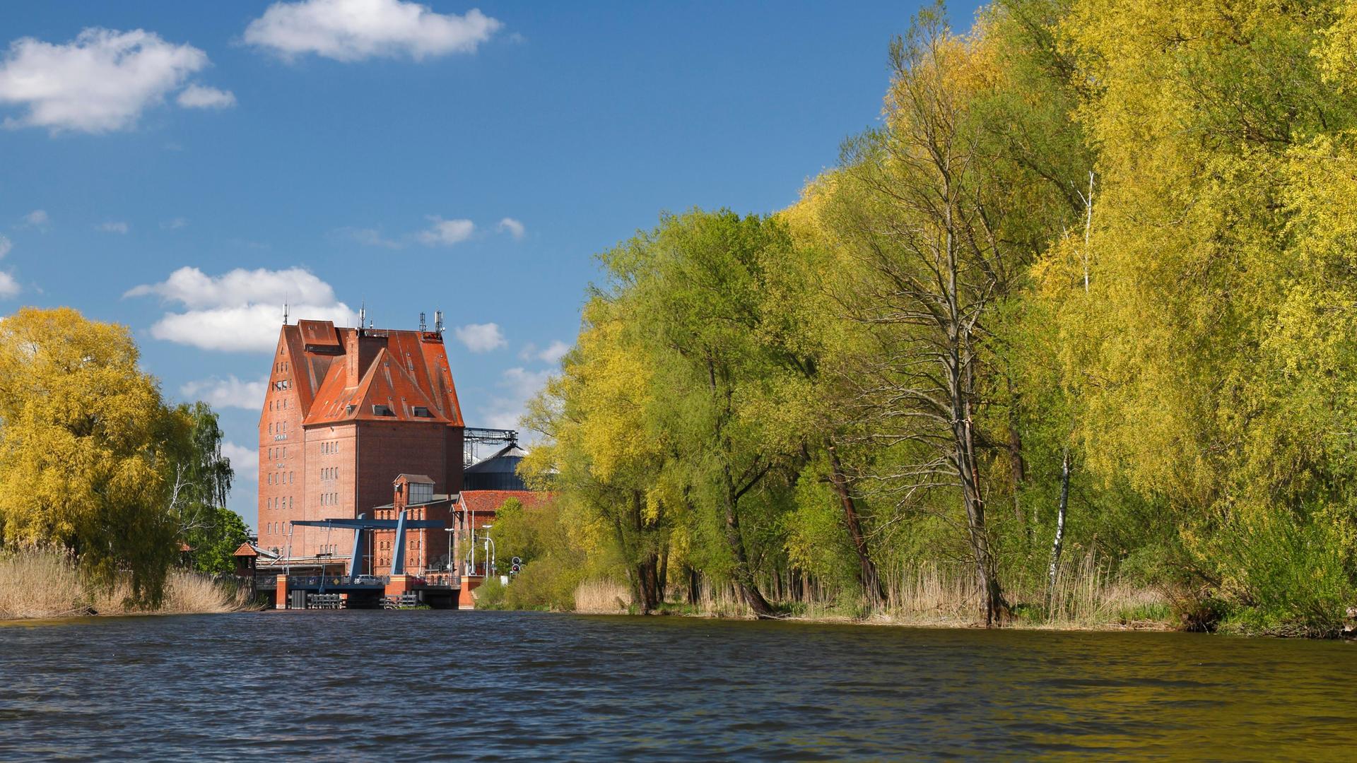 Der Fluss Peene in Mecklenburg-Vorpommern mit dem Speichergebäude aus Backstein im Hafen von Demmin.