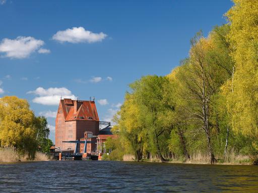 Der Fluss Peene in Mecklenburg-Vorpommern mit dem Speichergebäude aus Backstein im Hafen von Demmin.