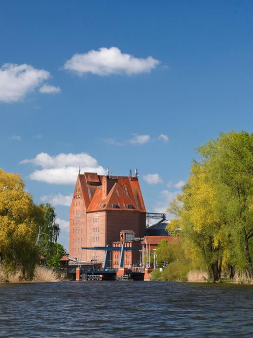 Der Fluss Peene in Mecklenburg-Vorpommern mit dem Speichergebäude aus Backstein im Hafen von Demmin.