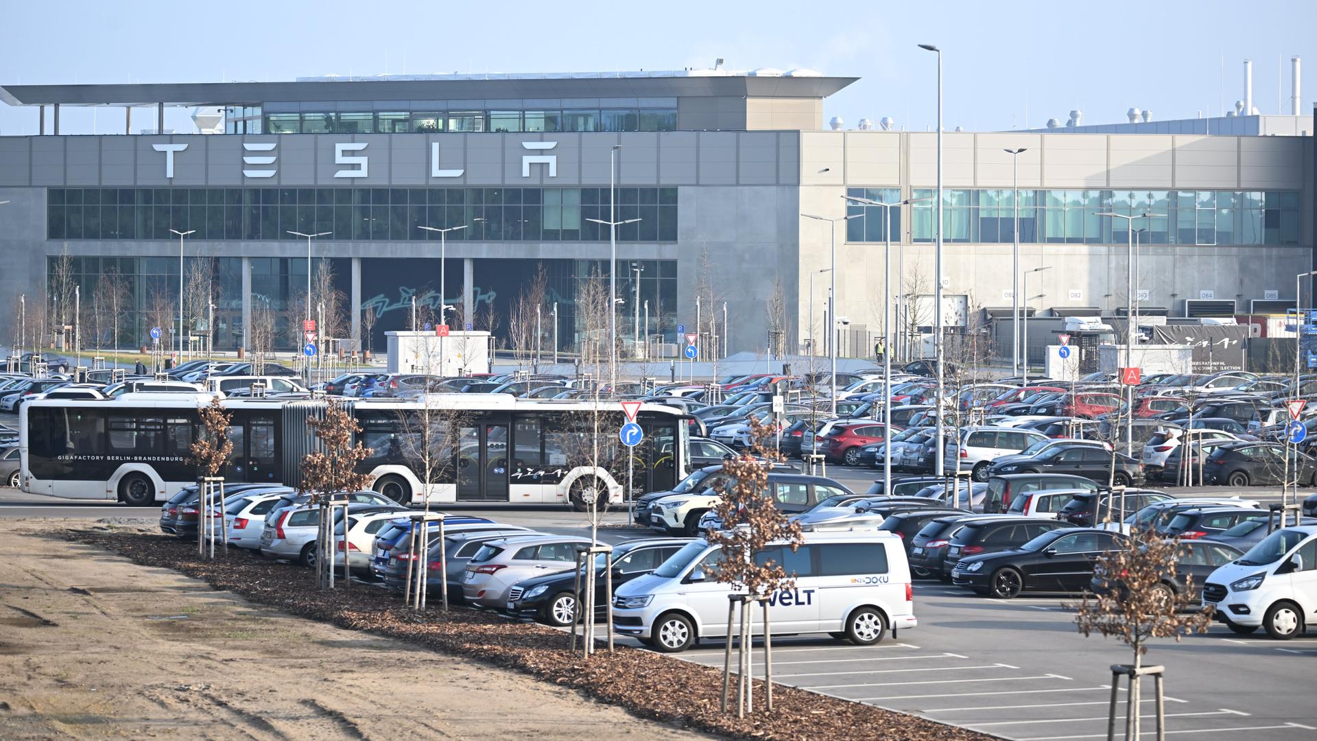 Grünheide: Die Morgensonne scheint auf den Eingang zum Tesla-Werk.