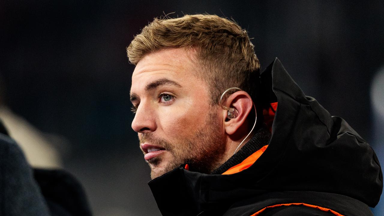 Christoph Kramer ist im Profil zu sehen. Er trägt eine schwarze Jacke mit neonorange farbenen Abnähern, im Ohr hat er einen in Ear Kopfhörer.