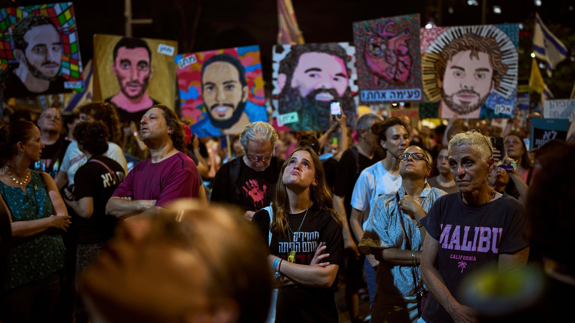 Das Bild zeigt Teilnehmende einer Kundgebung bei Nacht. Sie halten Bilder von Verschleppten hoch, für deren Freilassung sie demonstrieren. Das Bild zeigt Teilnehmende einer Kundgebung bei Nacht. Sie halten Bilder von Verschleppten hoch, für deren Freilassung sie demonstrieren.