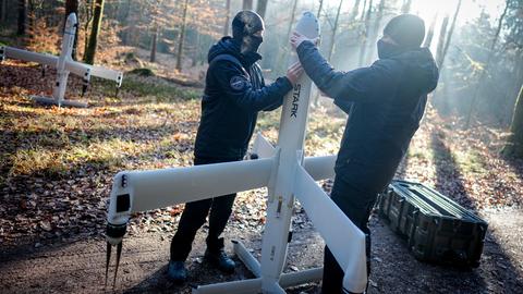 Mitarbeiter der Firma Stark Defence, die nicht erkannt werden möchten, demonstrieren in einem Waldstück in der Nähe des Sprengplatzes den Aufbau ihrer Drohnenwaffe "Virtus".
