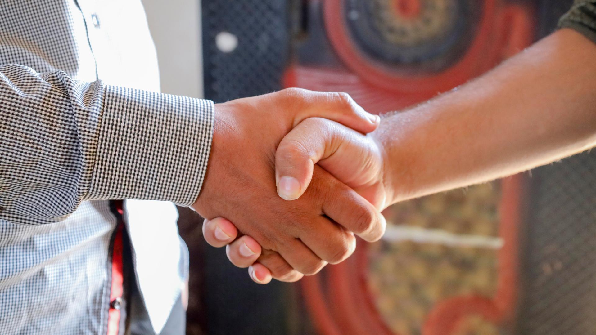 Handschlag: Zwei Menschen schütteln sich die Hand.