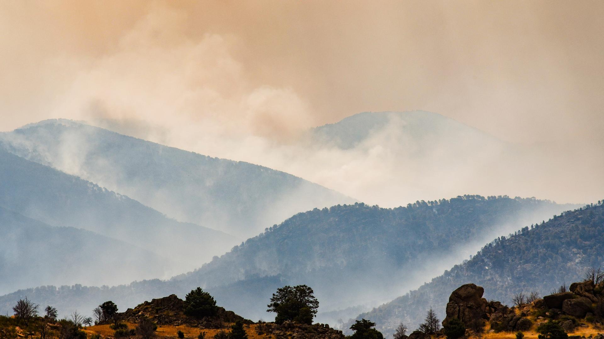 Rauchsäulen des Waldbrands westlich von Madrid liegen über den Hügeln.