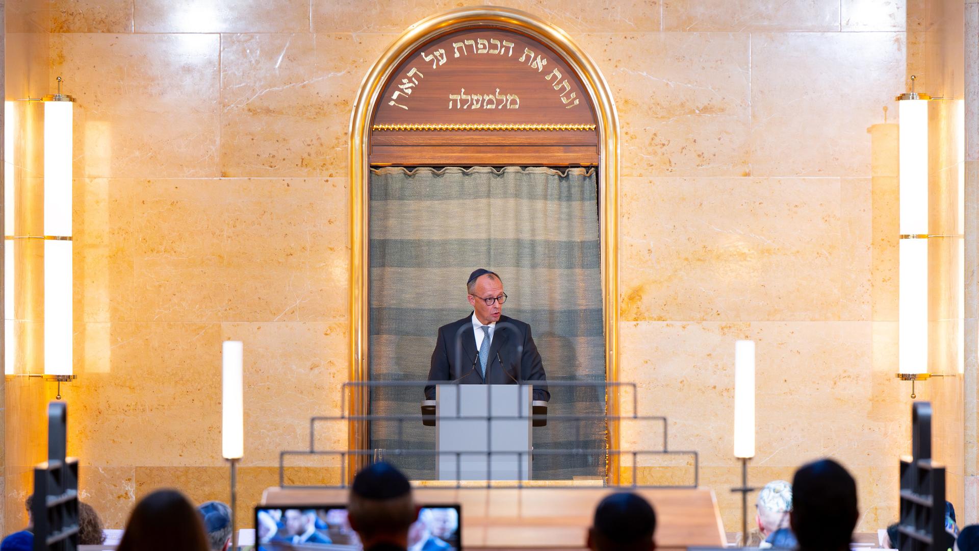 Bundeskanzler Friedrich Merz (CDU) steht während des Festakts zur Wiederherstellung der Synagoge Reichenbachstraße in München auf der Kanzel und spricht. Im Vordergrund sitzen mehrere Menschen und hören ihm zu. Bundeskanzler Friedrich Merz (CDU) steht während des Festakts zur Wiederherstellung der Synagoge Reichenbachstraße in München auf der Kanzel und spricht. Im Vordergrund sitzen mehrere Menschen und hören ihm zu.