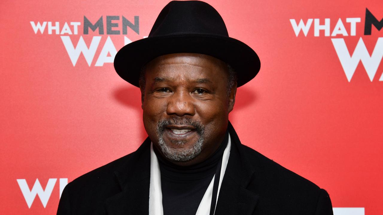 Das Bild zeigt den US-Schauspieler Isiah Whitlock Jr.; er trägt eine schwarze Jacke und einen schwarzen Hut und lächelt in die Kamera.