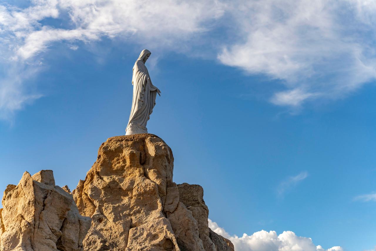 Statue der Jungfrau Maria auf einem Felsen neben der Wallfahrtskapelle Notre Dame de la Serra in Calvi, Balagne, Korsika, Frankreich. Statue der Jungfrau Maria auf einem Felsen neben der Wallfahrtskapelle Notre Dame de la Serra in Calvi, Balagne, Korsika, Frankreich.