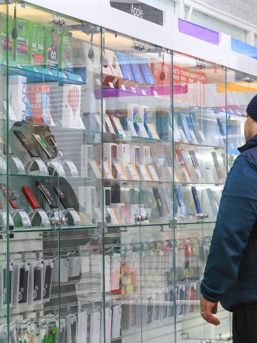 Ein Mann steht in einem Handyladen in einem russischen Einkaufszentrum. 