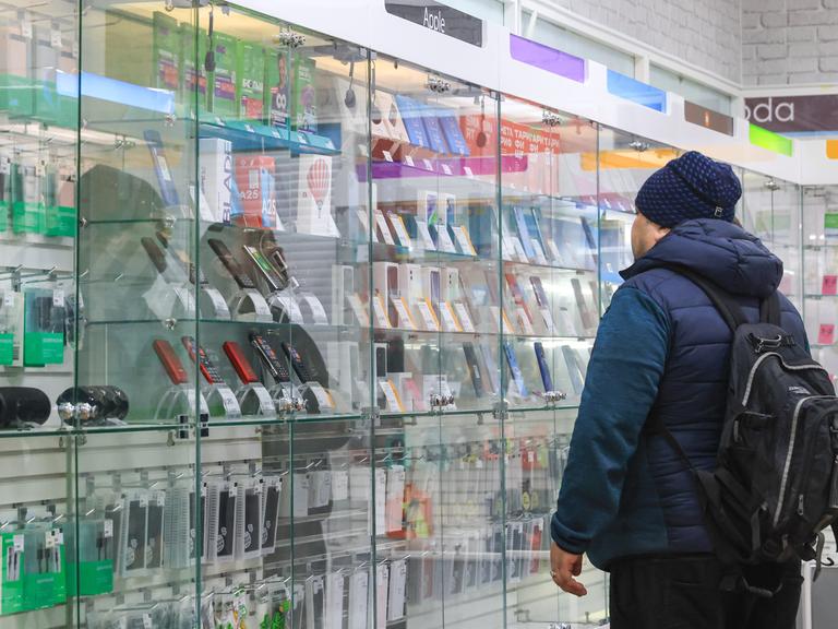 Ein Mann steht in einem Handyladen in einem russischen Einkaufszentrum. 
