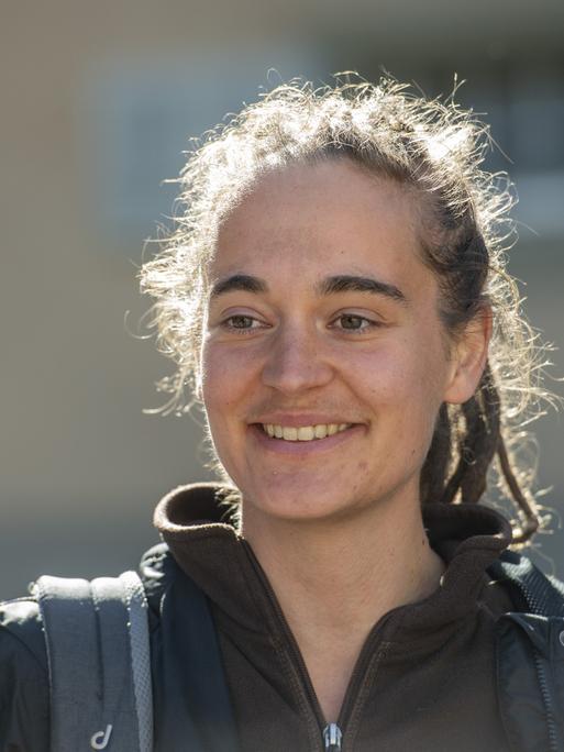 Porträt der deutschen Aktivistin und freiwilligen Seenotretterin Carola Rackete, die lächelnd nach vorne schaut.