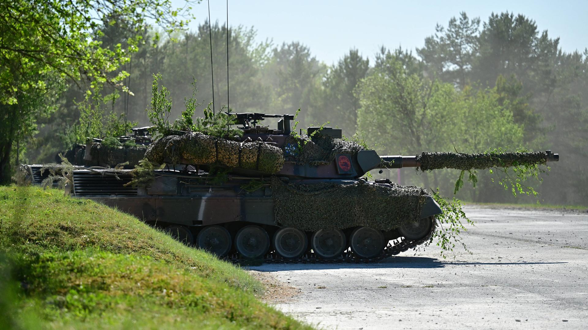 Ein Panzer fährt während einer Militärvorführung durchs Gelände. 