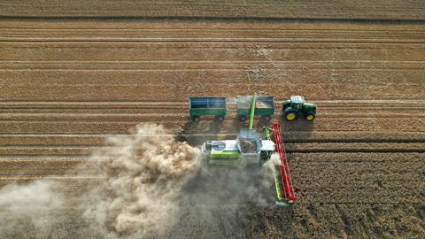 Mähdrescher und Transportfahrzeug auf einem Getreideacker
