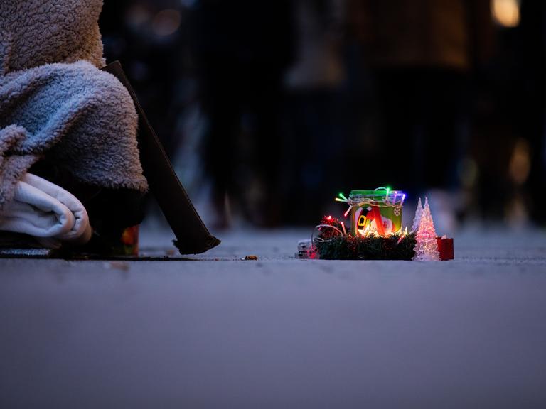 Ein Obdachloser bittet mit einer weihnachtlich gestalteten Spendendose um Geld. Ein Obdachloser bittet mit einer weihnachtlich gestalteten Spendendose um Geld.