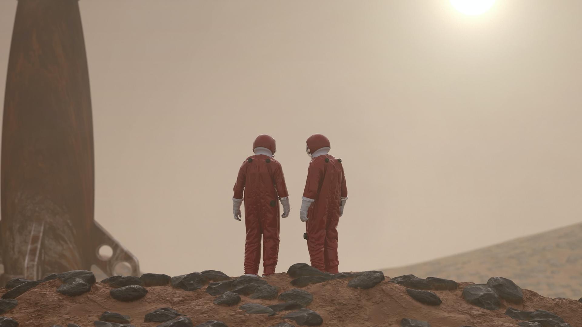 Zwei Personen in roten Ganzkörperanzügen auf rotem, steinigen Untergrund. Neben ihnen eine Rakete, aufrecht stehend. Am Horizont die Sonne.