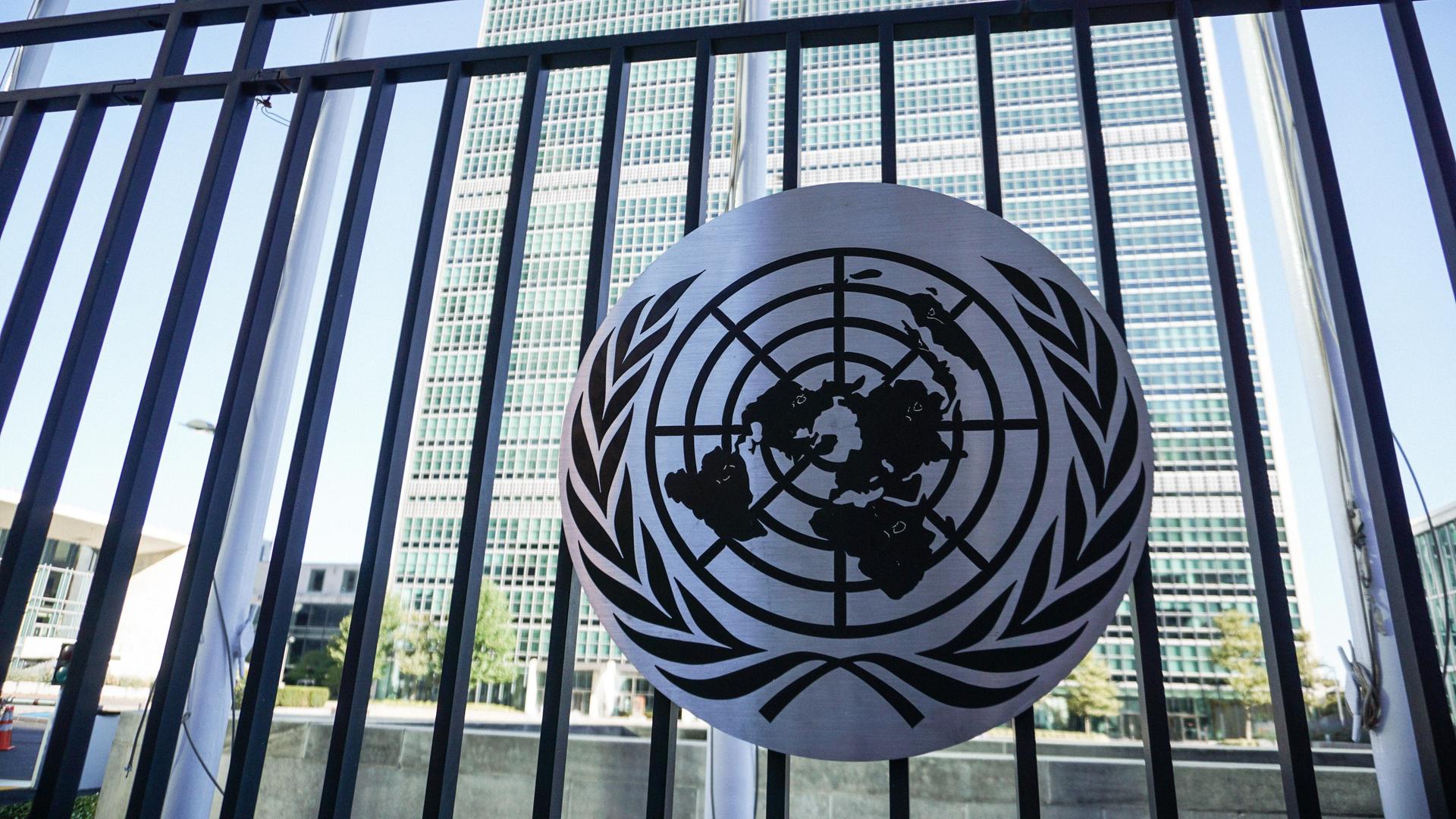 Ein Schild mit dem Logo der Vereinten Nationen vor dem UN-Hauptquartier in New York.  