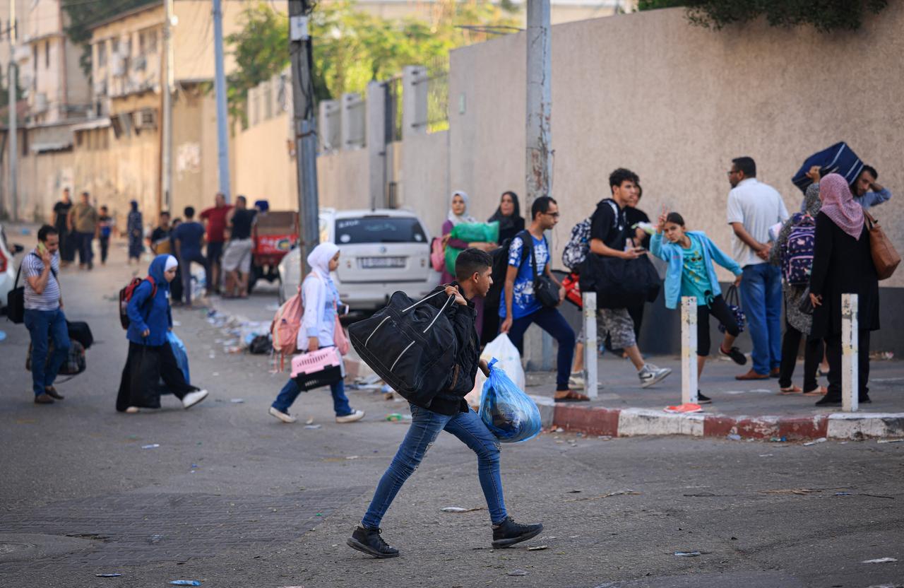 Palästinenser fliehen beladen mit Taschen und Säcken in Gaza-Stadt.