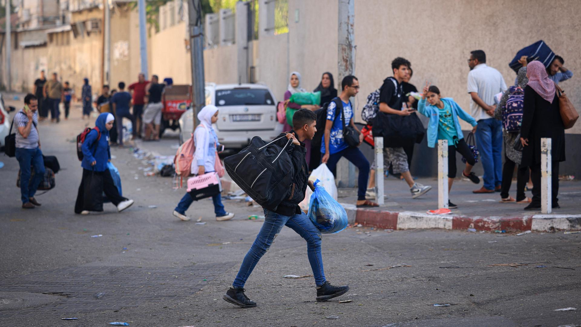 Palästinenser fliehen beladen mit Taschen und Säcken aus Gaza-Stadt.