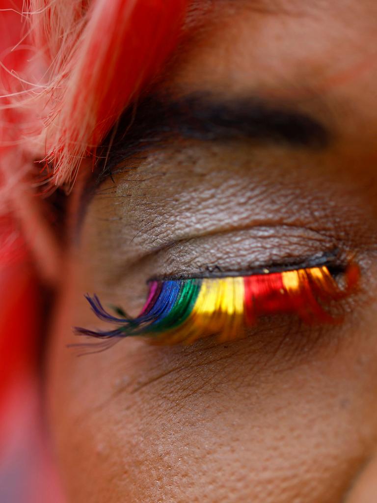 Nahaufnahme eines Auges mit False Lashes in Regenbogenfarben.