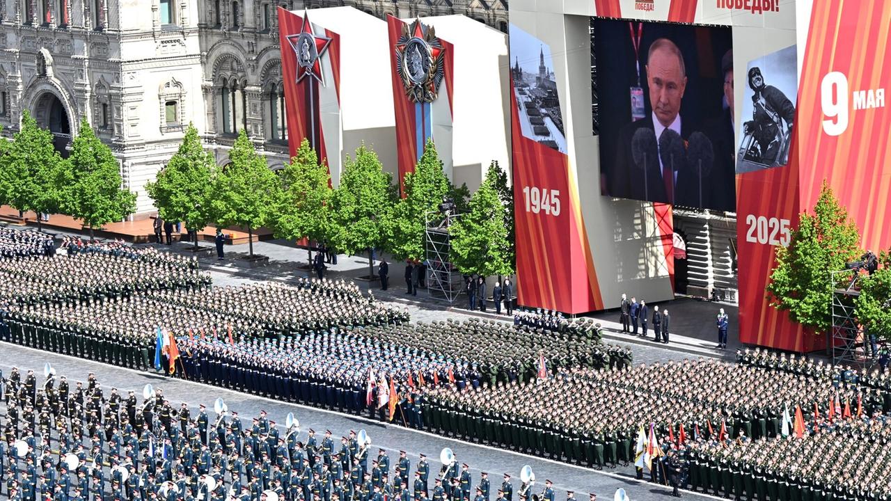 Unzähliche Soldaten marschieren, darüber zeigt eine große Videoleinwand Putin: Militärparade zum 80. Jahrestag des Sieges über Nazideutschland in Moskau.