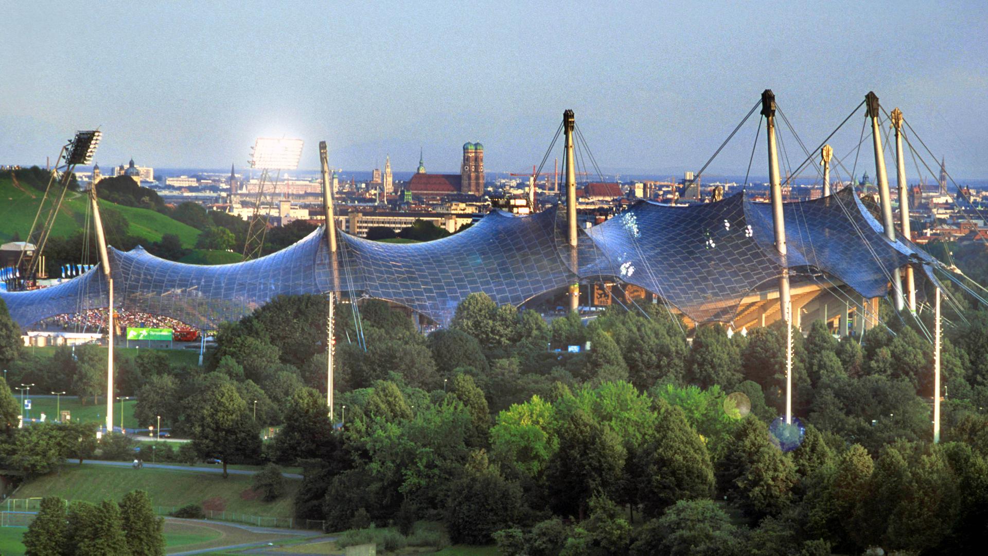 Das Olympiagelände in München mit dem Zeltdach des Stadion. Im Hintergrund das Stadtpanorama mit Frauenkirche Das Olympiagelände in München mit dem Zeltdach des Stadion. Im Hintergrund das Stadtpanorama mit Frauenkirche