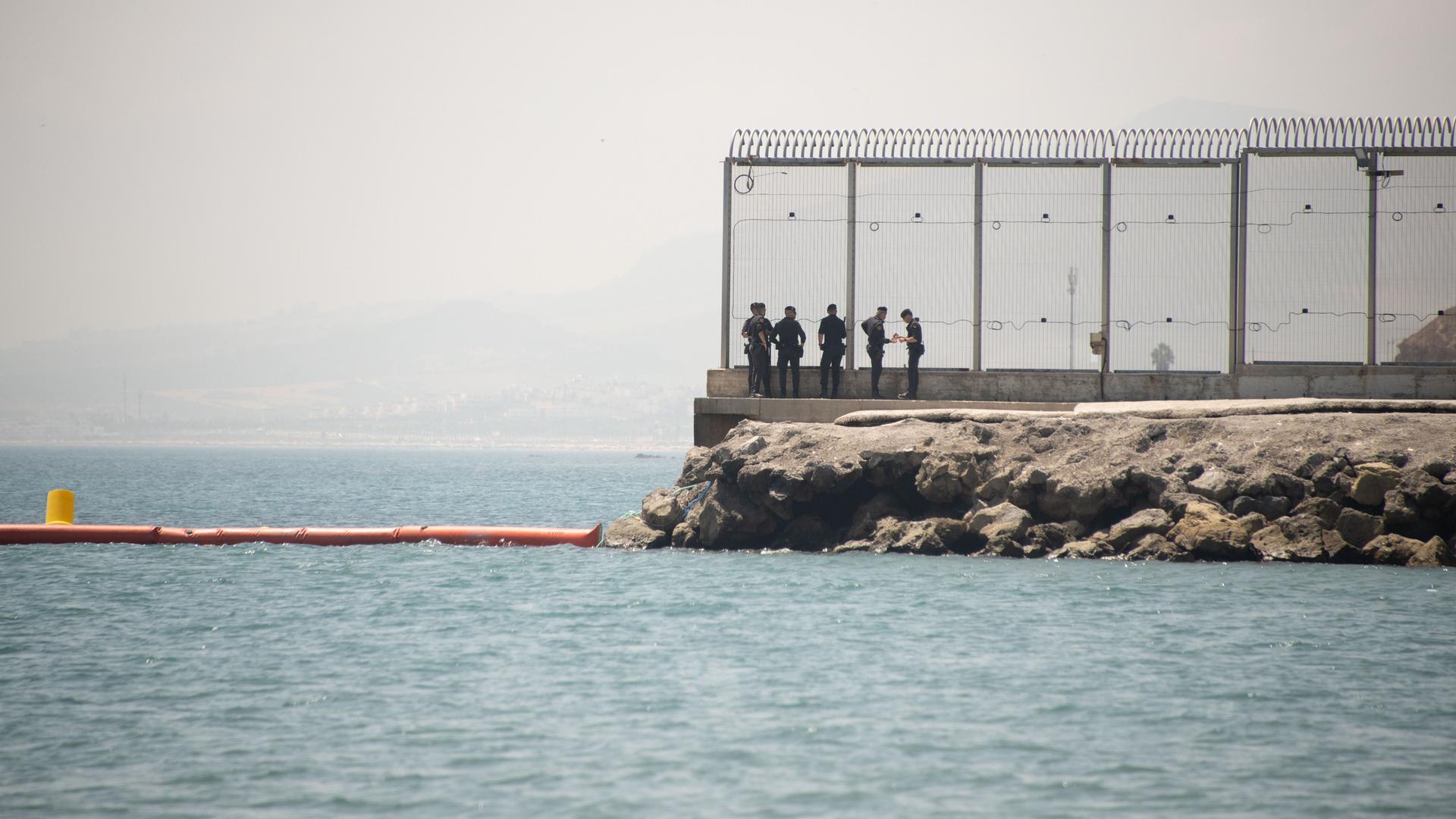 Sicherheitspersonal steht an einem Zaun an der Grenze von Ceuta, Spanien, am 15. August 2026