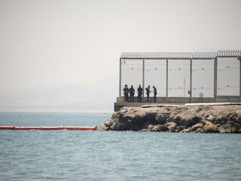Sicherheitspersonal steht an einem Zaun an der Grenze von Ceuta, Spanien, am 15. August 2026 Sicherheitspersonal steht an einem Zaun an der Grenze von Ceuta, Spanien, am 15. August 2026