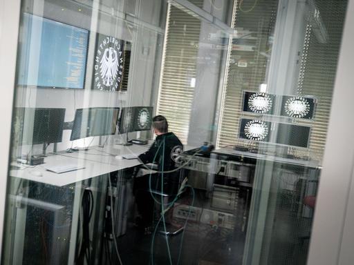 Ein Informatiker und Hacker spiegelt sich in der Scheibe zu einem Serverraum des Bundesnachrichtendienstes (BND) in Berlin