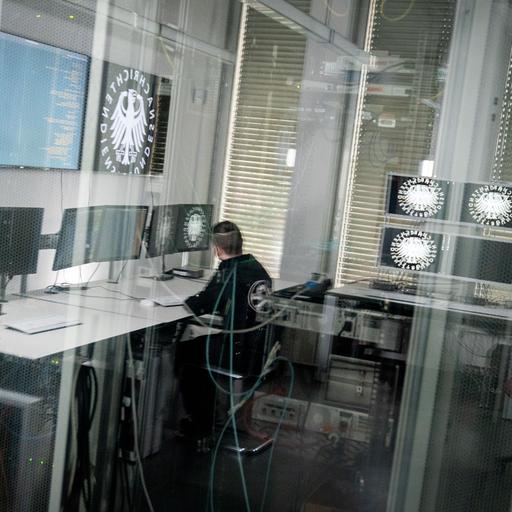 Ein Informatiker und Hacker spiegelt sich in der Scheibe zu einem Serverraum des Bundesnachrichtendienstes (BND) in Berlin