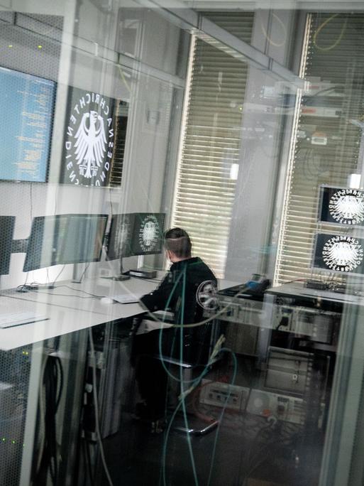 Ein Informatiker und Hacker spiegelt sich in der Scheibe zu einem Serverraum des Bundesnachrichtendienstes (BND) in Berlin