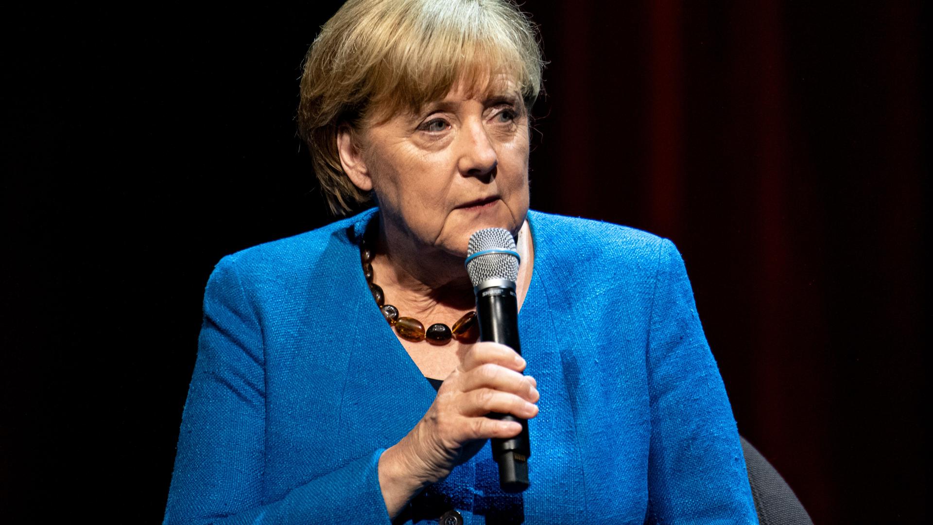 Porträt von Merkel mit Micro in der Hand. Porträt von Merkel mit Micro in der Hand.