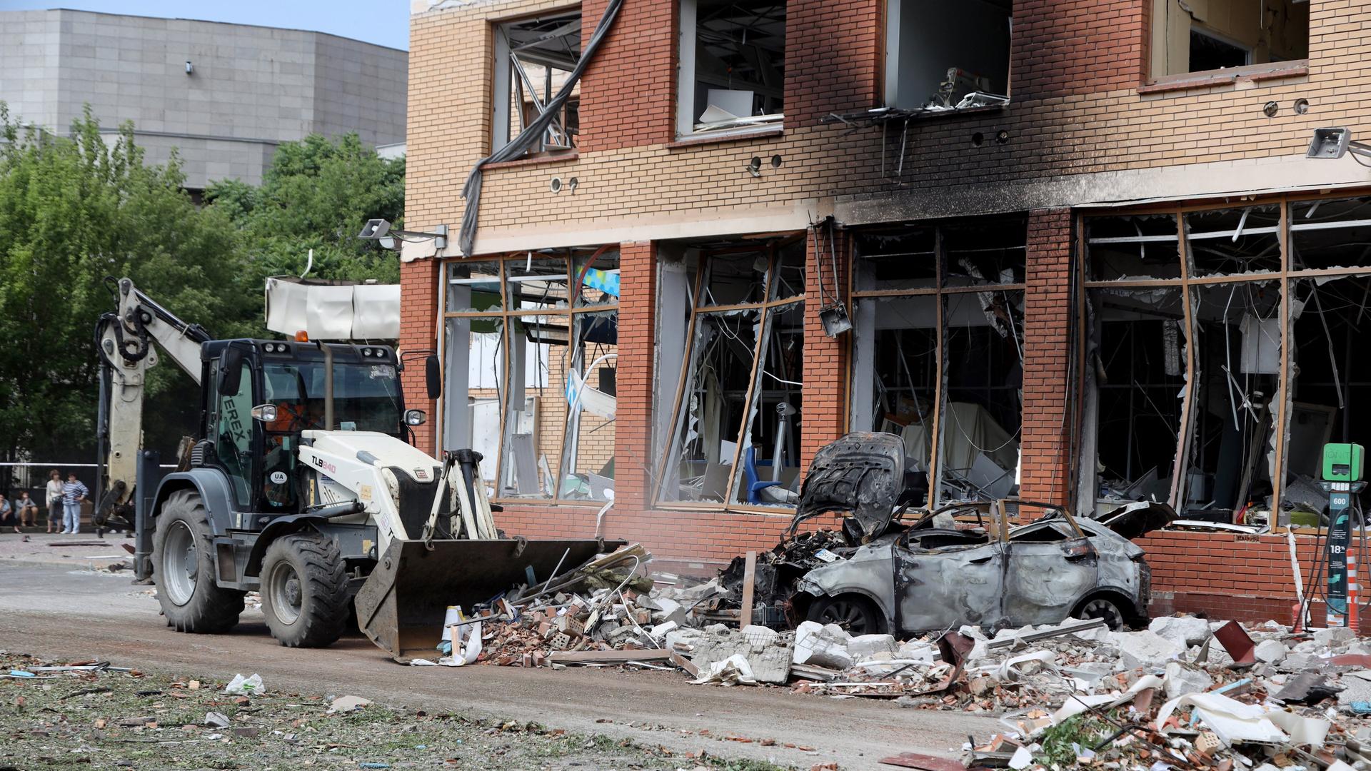 Ein Traktor räumt vor einem zerstörten Haus in Odessa in der Ukraine Schutt weg. Ein Traktor räumt vor einem zerstörten Haus in Odessa in der Ukraine Schutt weg.