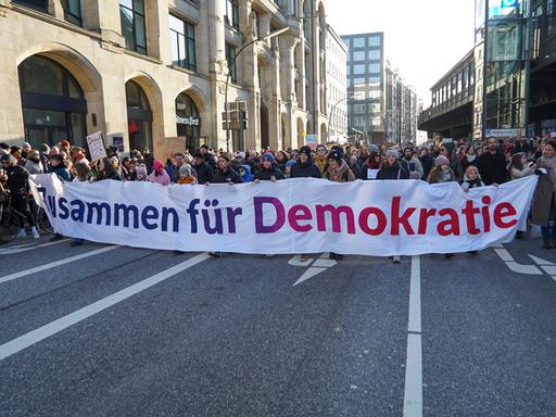 Demonstranten in Hamburg tragen einen Banner mit der Aufschrift "Zusammen für Demokratie".