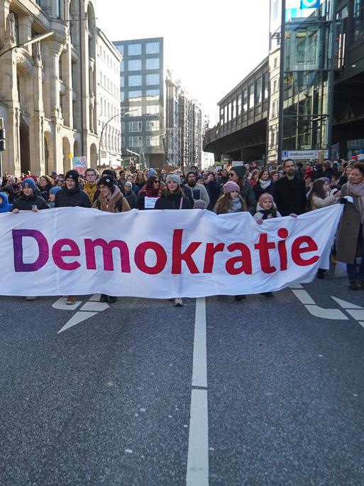 Demonstranten in Hamburg tragen einen Banner mit der Aufschrift "Zusammen für Demokratie".