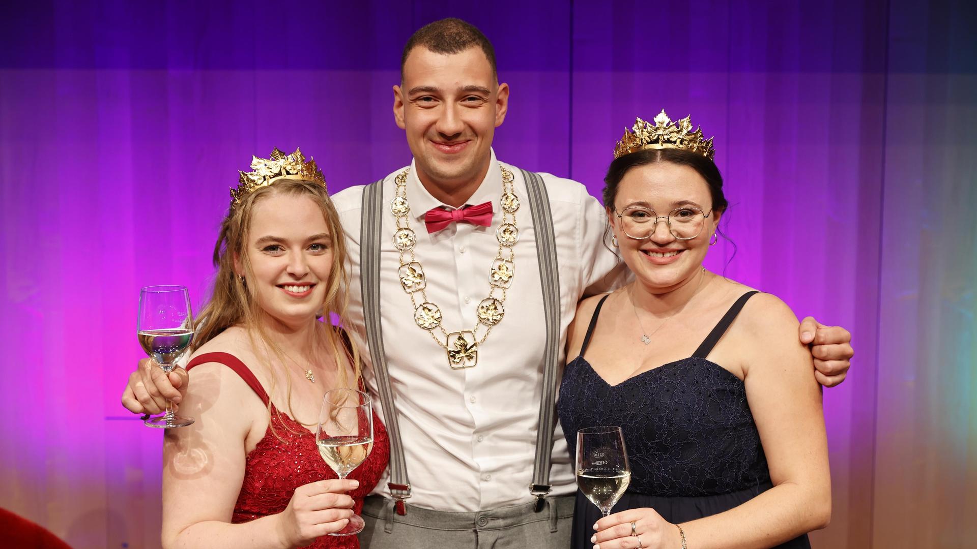 Levin McKenzie (M), Katja Klemmer (l) und Laura Schlösser (r). Sie haben Weingläser in der Hand.