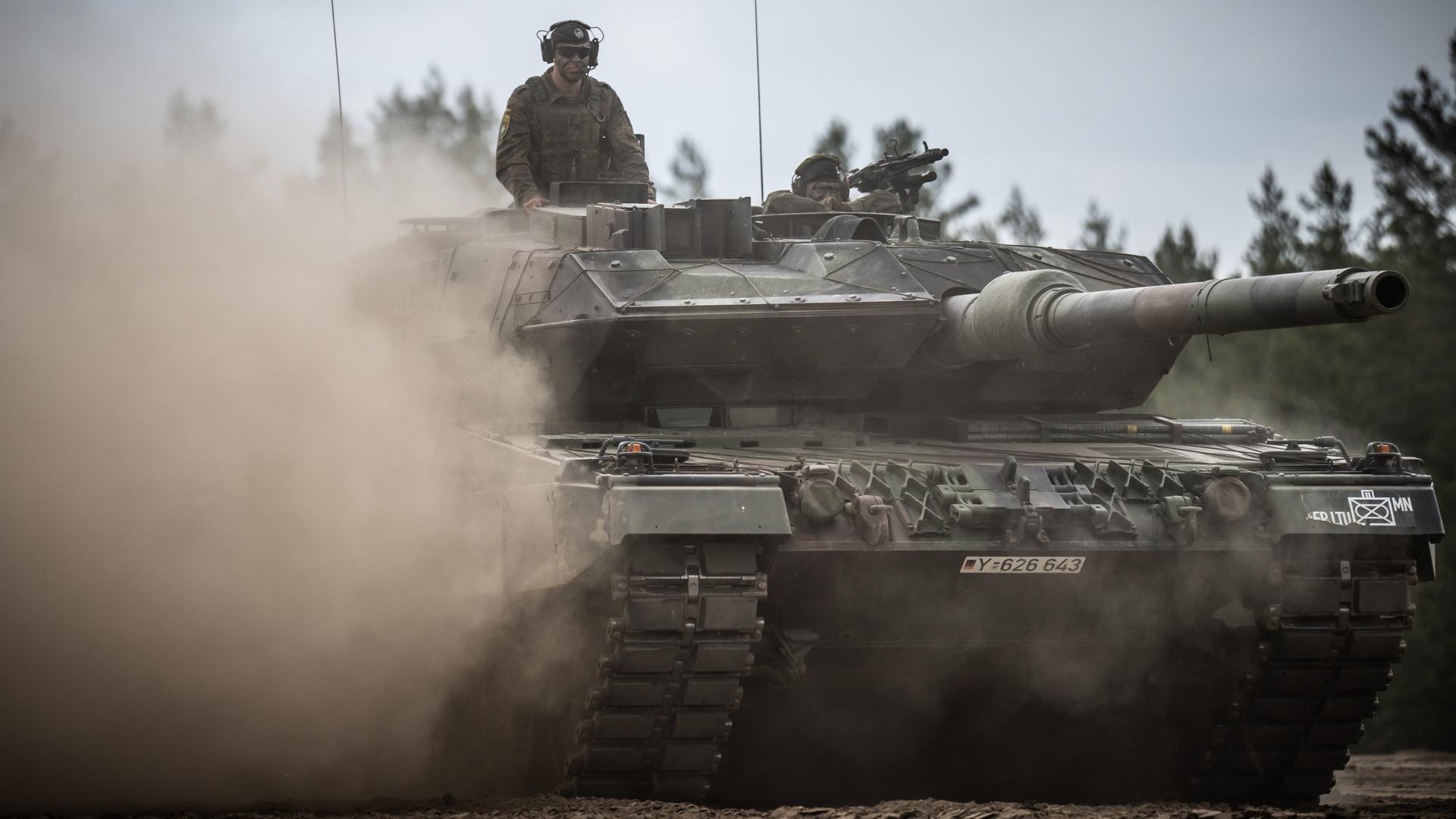 Aus einem fahrenden Leopard-2-Panzer schaut ein Soldat.