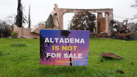 Im Garten vor der Ruine eines Wohnhauses steht ein Schild mit der Aufschrift "Altadena ist not for Sale".