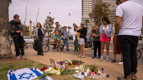 Zu sehen sind Passanten in Tel Aviv am Ort eines Anschlags, bei dem ein Mann getötet wurde.