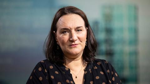 Terézia Mora trägt ein schwarzes Kleid mit braunen Punkten und schaut in die Kamera.