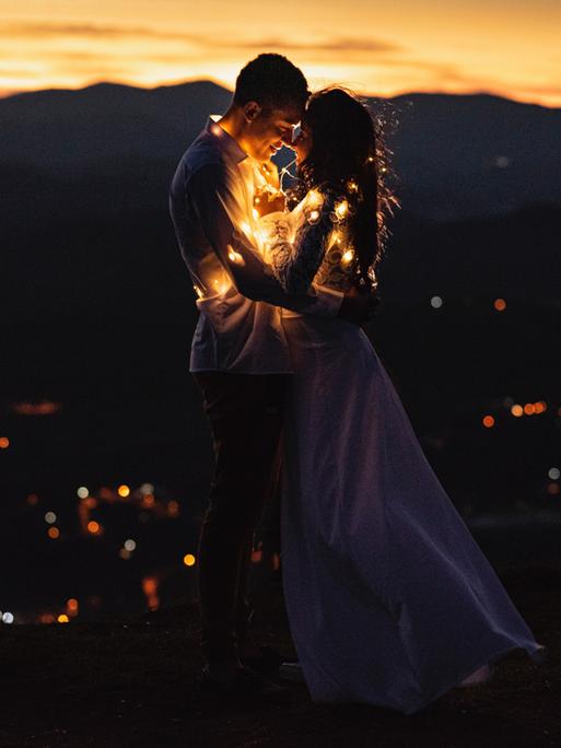 ein Hochzeitspaar eingehüllt in eine Lichterkette ein Hochzeitspaar eingehüllt in eine Lichterkette