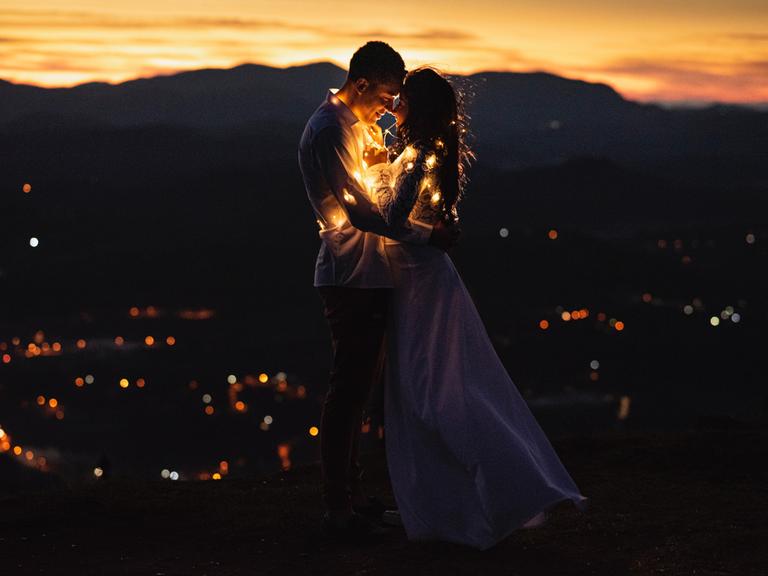 ein Hochzeitspaar eingehüllt in eine Lichterkette ein Hochzeitspaar eingehüllt in eine Lichterkette